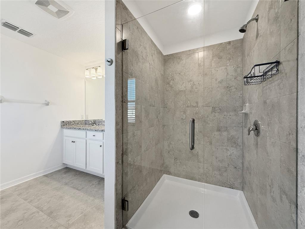 3023 Adams Cross Drive Zephyrhills, FL 33540 - Photo 23 of 36 a bathroom with a granite countertop sink a shower and mirror