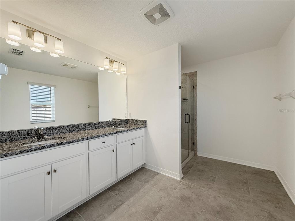 3023 Adams Cross Drive Zephyrhills, FL 33540 - Photo 10 of 36 a bathroom with a granite countertop sink and a mirror