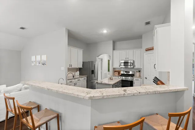 a kitchen with stainless steel appliances kitchen island sink refrigerator and cabinets