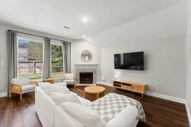 a living room with furniture a flat screen tv and a fireplace