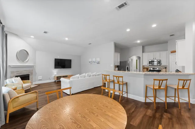 a living room with furniture a flat screen tv and kitchen view