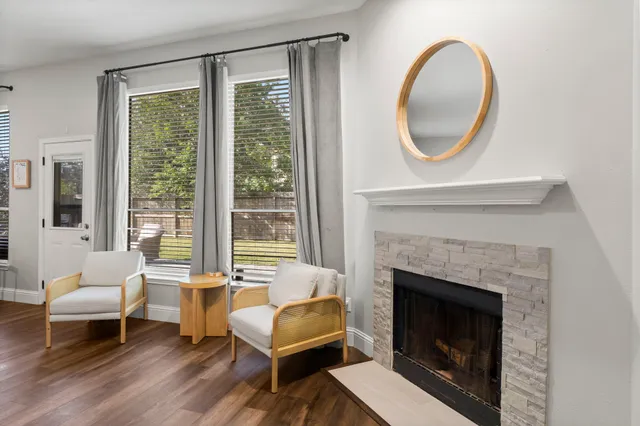 a living room with furniture a large window and a fireplace