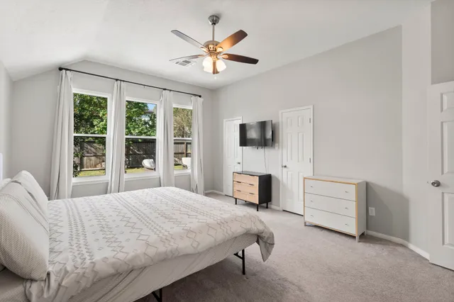 a bedroom with a bed a chandelier and a couch