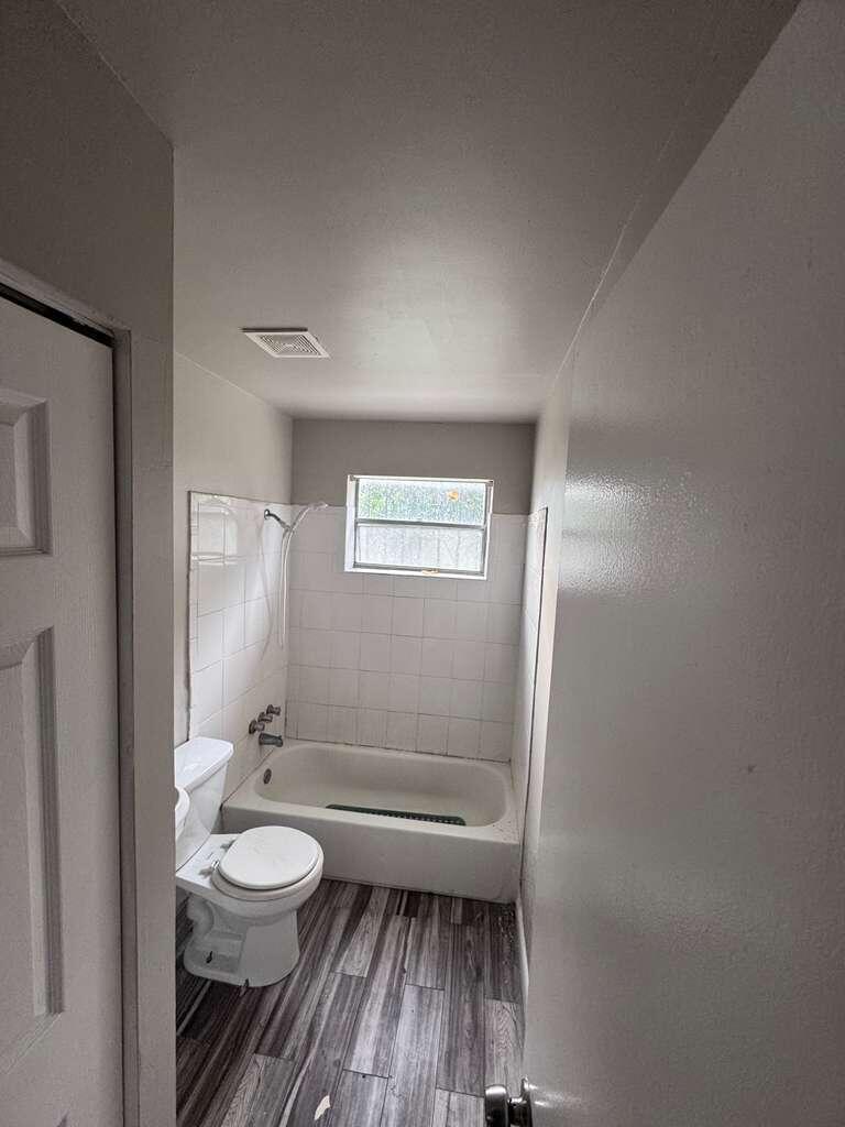 3309 Avenue South Riviera Beach, FL 33404 - Photo 7 of 17 a bathroom with a toilet a sink and mirror