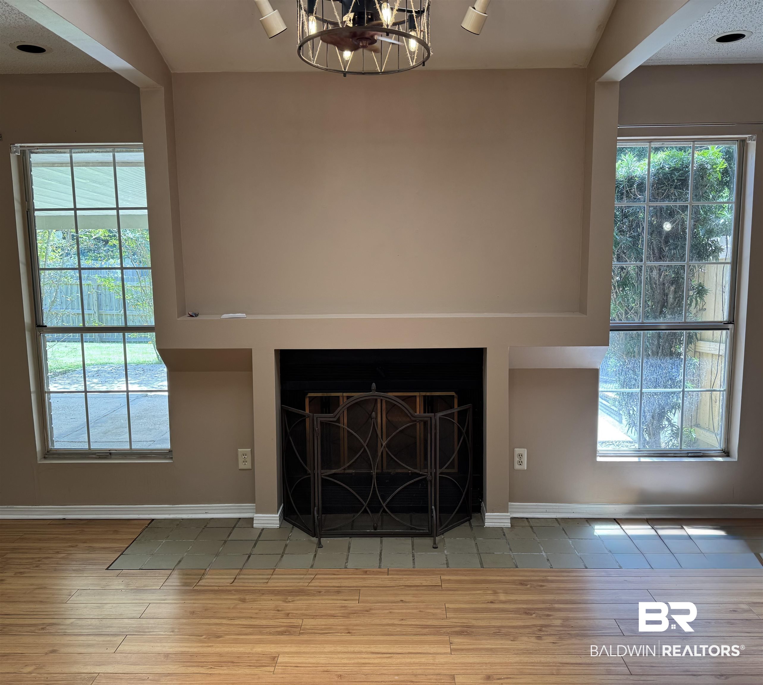 8070 Middle Ring Road Mobile, AL 36619 - Photo 6 of 26 Detailed view of wood finished floors, a fireplace with flush hearth, and a chandelier