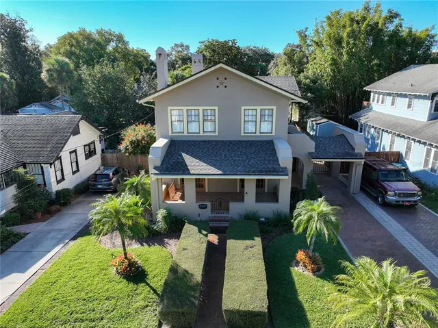 a front view of a house with a yard and potted plants