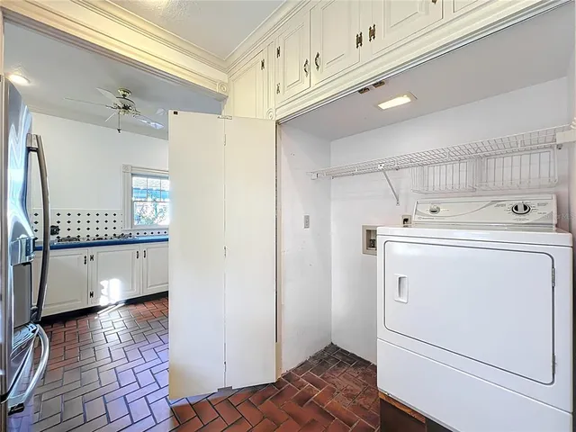 a view of a house with brick walls and a yard with plants