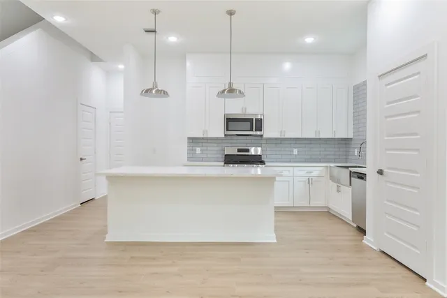 a kitchen with a stove sink and cabinets