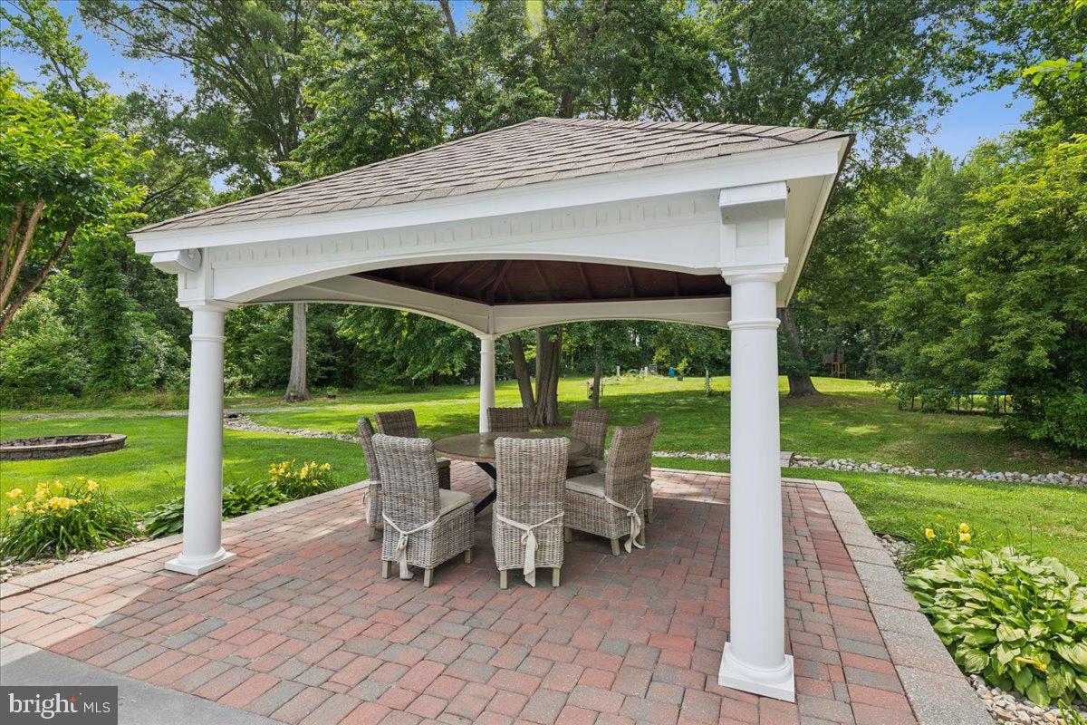 102 Little Neck Road Stevensville, MD 21666 - Photo 62 of 77 a view of a patio with lawn chairs floor to ceiling window and yard