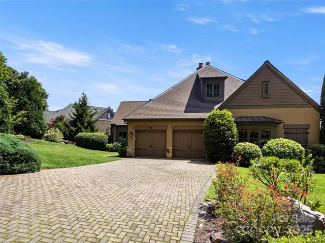 a front view of a house with a yard and potted plants