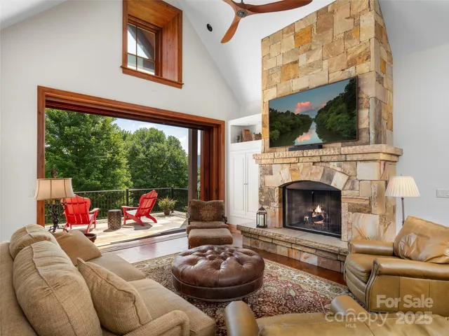 a living room with furniture a fireplace and a floor to ceiling window