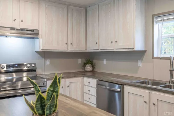 a kitchen with stainless steel appliances granite countertop a sink a stove and white cabinets