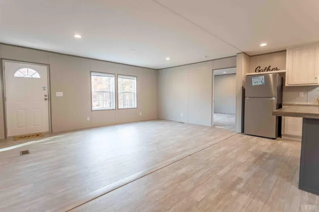 a view of empty room with wooden floor and windows