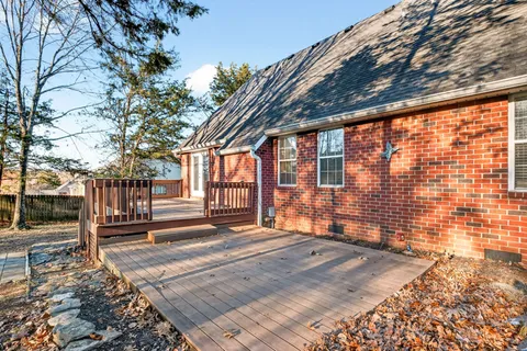a view of a backyard with wooden fence and large trees