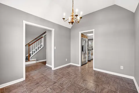 a view of an empty room with window and stairs