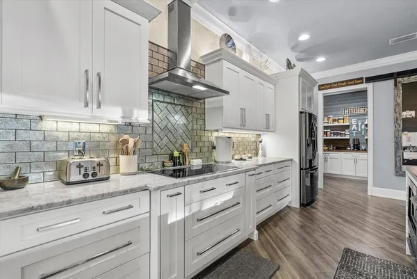 a kitchen with granite countertop cabinets and wooden floor