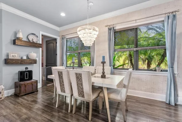 a view of a dining room with furniture large windows and wooden floor