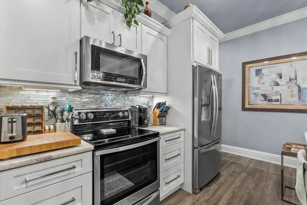 a kitchen with stainless steel appliances a stove microwave and refrigerator