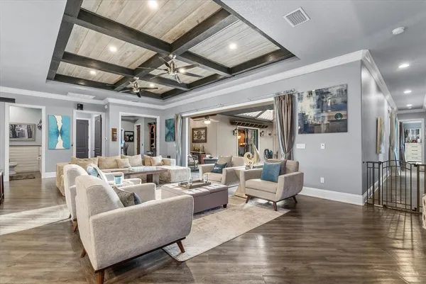 a living room with furniture wooden floor and ceiling fan