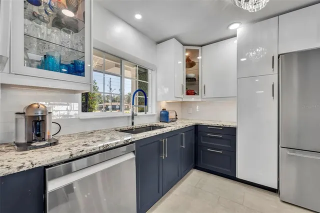 a large kitchen with stainless steel appliances granite countertop a stove and a sink