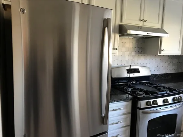 a kitchen with granite countertop cabinets stainless steel appliances and a window