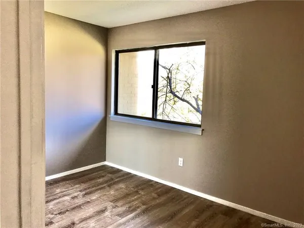 an empty room with wooden floor and shower