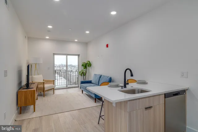 a living room with a sink and a table with wooden floor