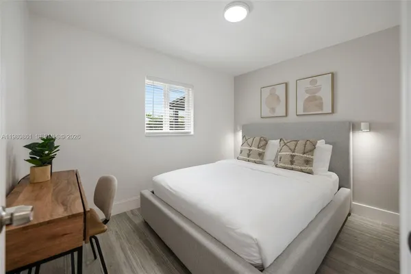 a bedroom with a bed chair and a potted plant
