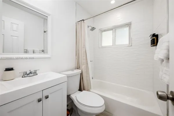 a bathroom with a sink a toilet a mirror and shower