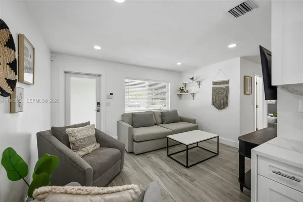 a living room with furniture and a wooden floor
