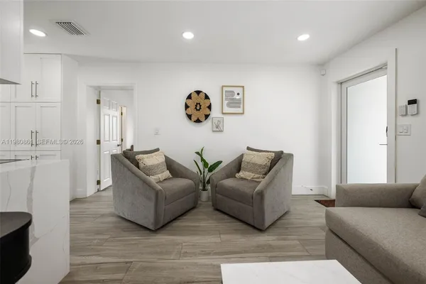 a living room with furniture and a wooden floor