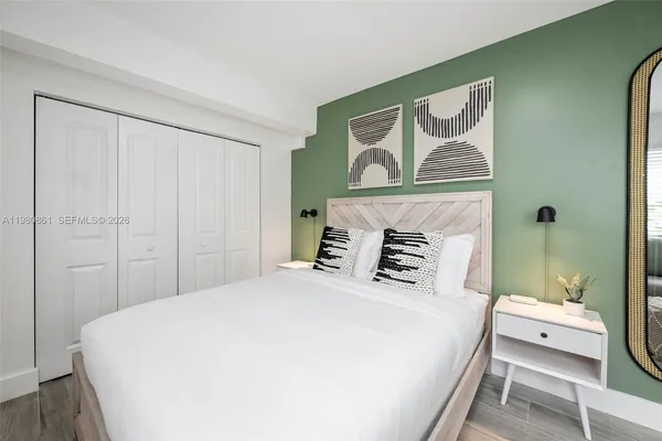 a bedroom with a bed and a painting on the wall