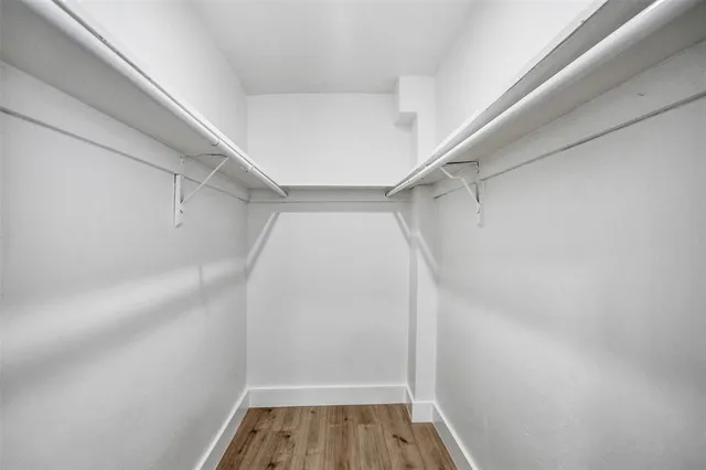 a view of walk in closet with empty racks