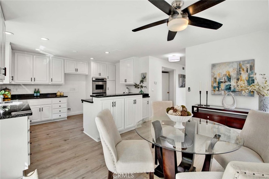 60 Willow Tree Lane Irvine, CA 92612 - Photo 19 of 74 a kitchen with stainless steel appliances kitchen island granite countertop a dining table chairs and a refrigerator