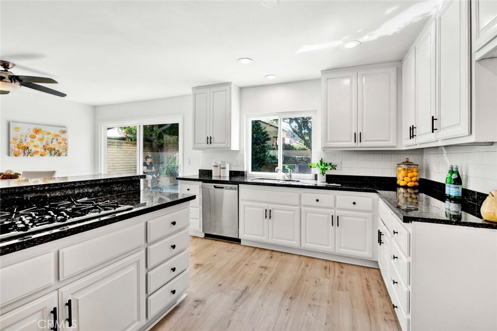 60 Willow Tree Lane Irvine, CA 92612 - Photo 25 of 74 a kitchen with stainless steel appliances granite countertop white cabinets sink stove and granite counter top