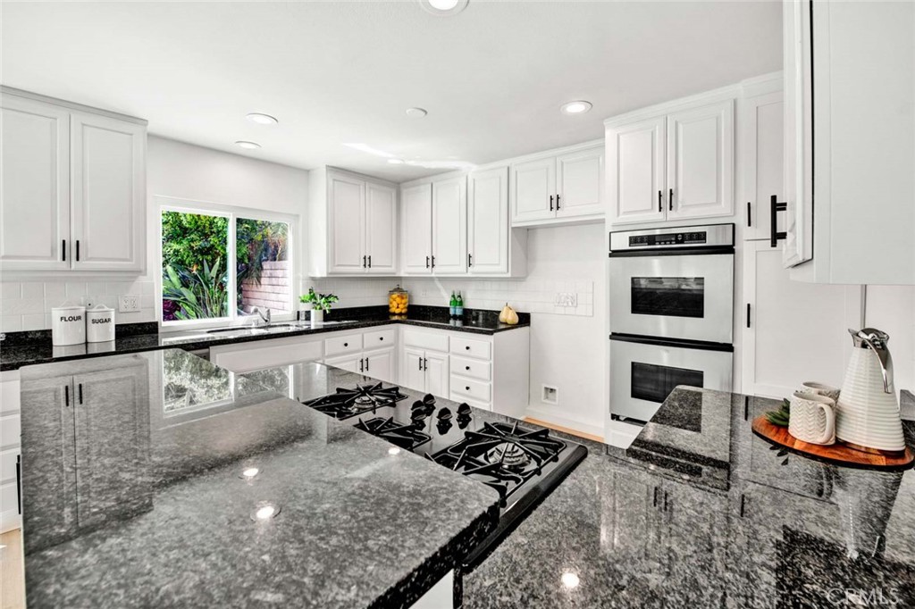60 Willow Tree Lane Irvine, CA 92612 - Photo 26 of 74 a kitchen with stainless steel appliances granite countertop a stove a sink a refrigerator and white cabinets