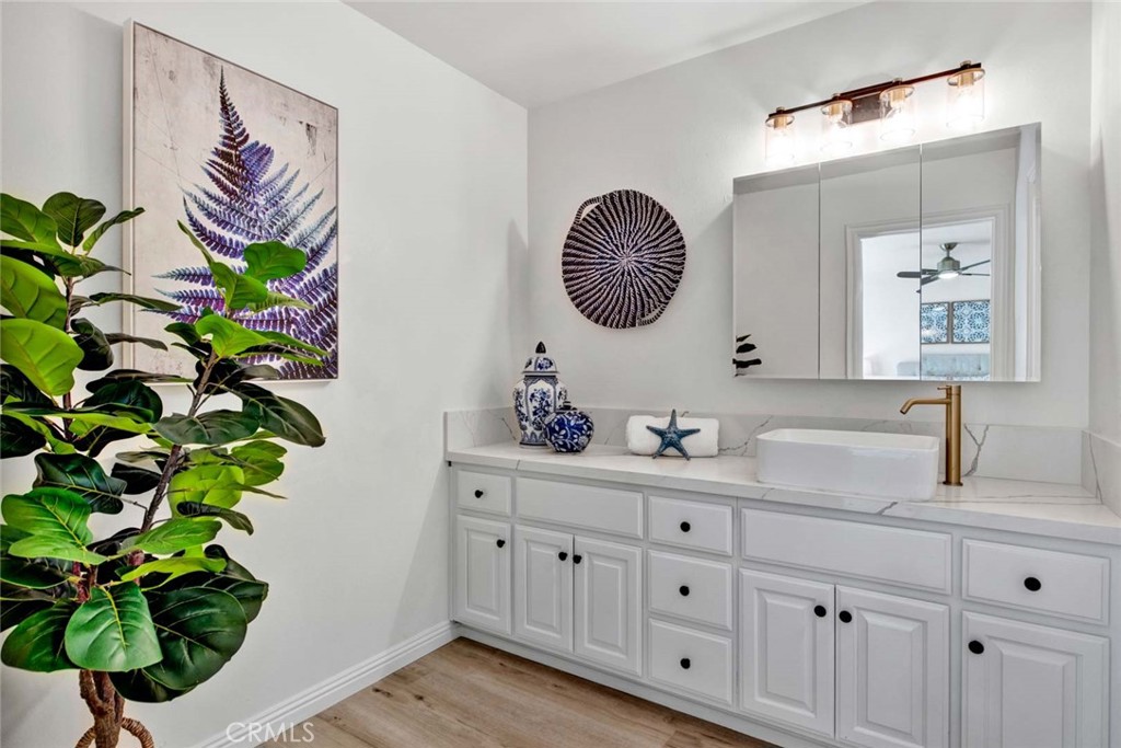 60 Willow Tree Lane Irvine, CA 92612 - Photo 36 of 74 a bathroom with a sink a mirror and a potted plant