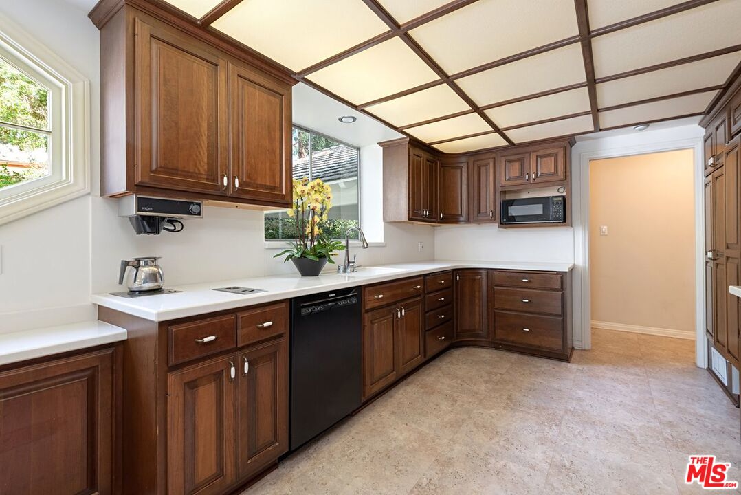 791 North Bundy Drive Los Angeles, CA 90049 - Photo 12 of 33 a kitchen with a sink and wooden cabinets