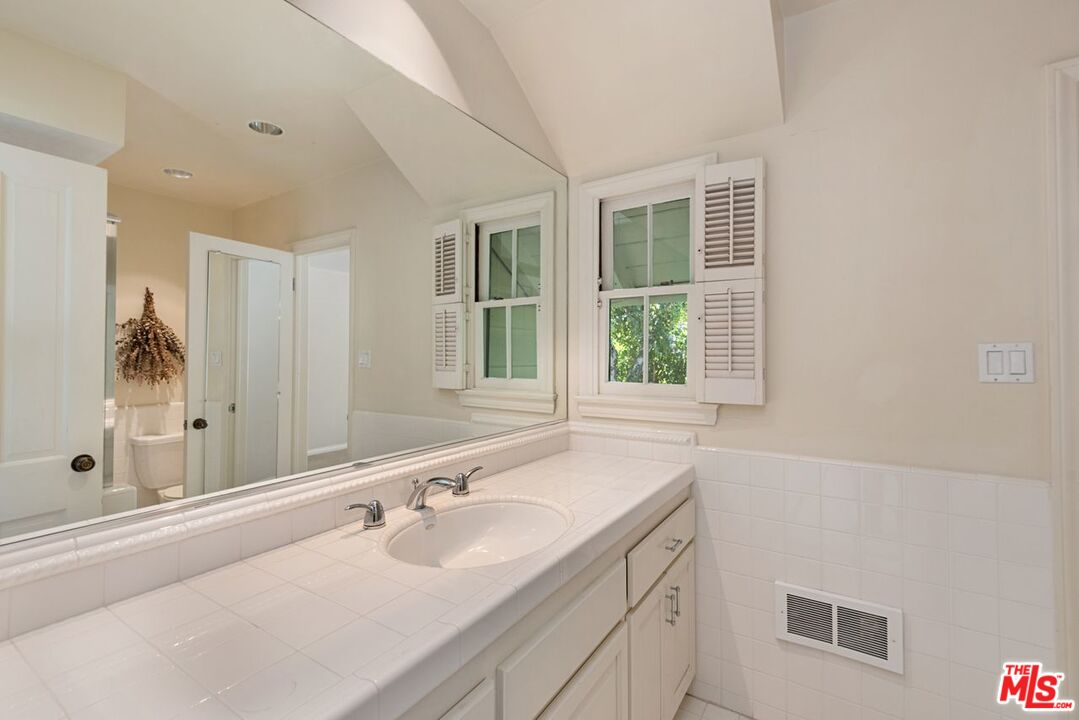 791 North Bundy Drive Los Angeles, CA 90049 - Photo 17 of 33 a bathroom with a sink and a mirror
