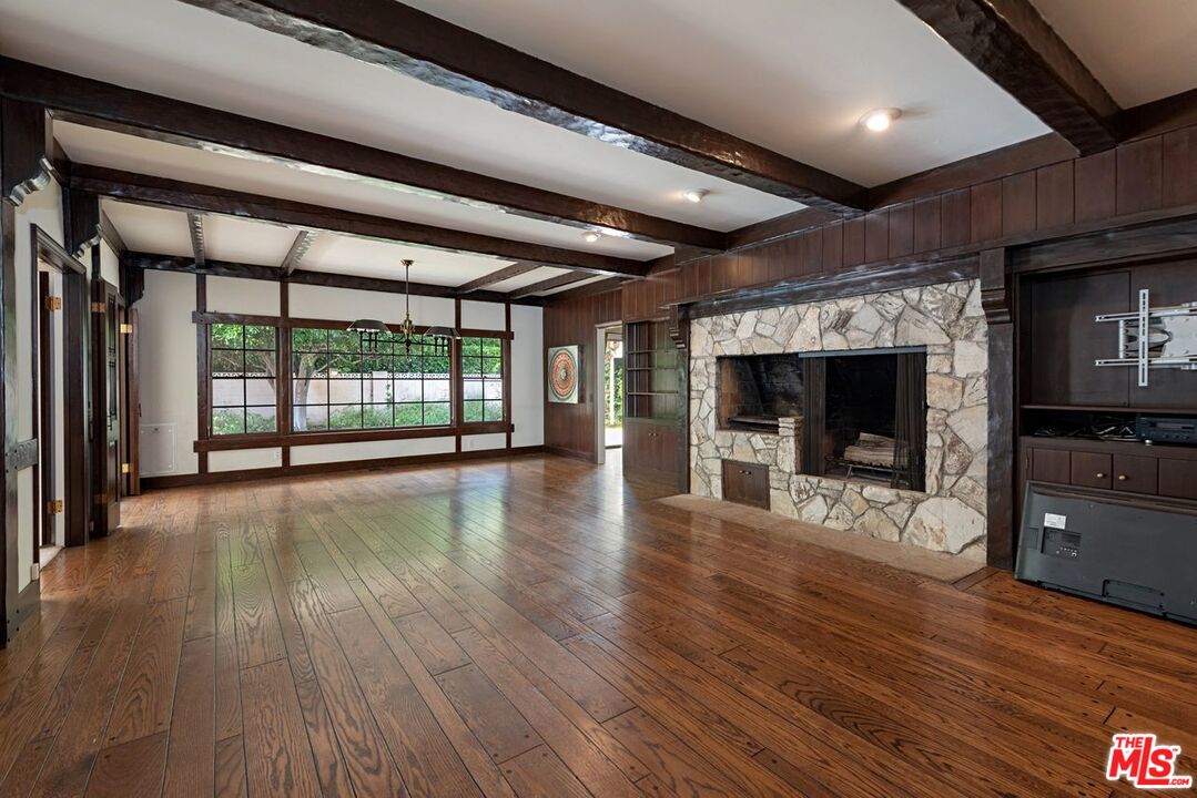 791 North Bundy Drive Los Angeles, CA 90049 - Photo 10 of 33 an empty room with wooden floor fireplace and windows