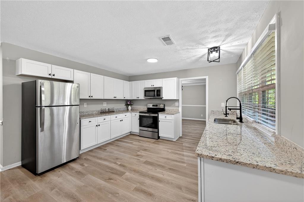 187 Old Timber Road Lawrenceville, GA 30046 - Photo 19 of 32 a kitchen with granite countertop a refrigerator and a sink