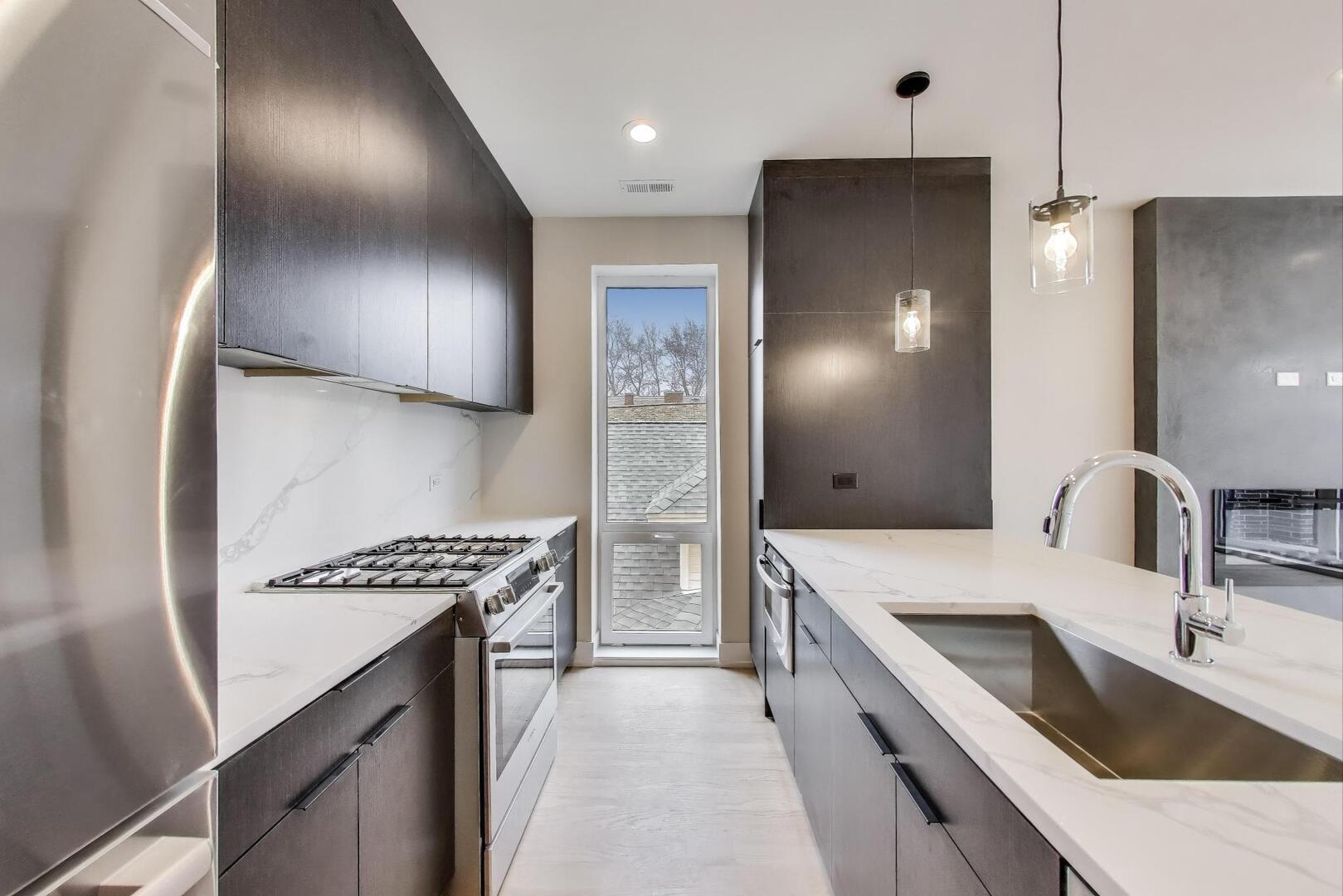 3339 North Ridgeway Avenue, Unit 2N Chicago, IL 60618 - Photo 7 of 29 a kitchen with stainless steel appliances a sink stove and refrigerator