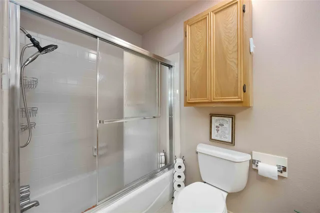 a white toilet sitting next to a bath tub shower