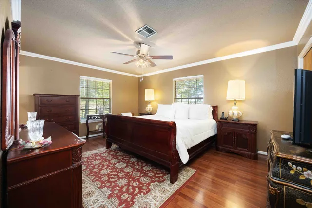 a bedroom with a bed and wooden floor