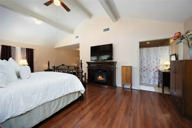 a spacious bedroom with a bed and a flat screen tv