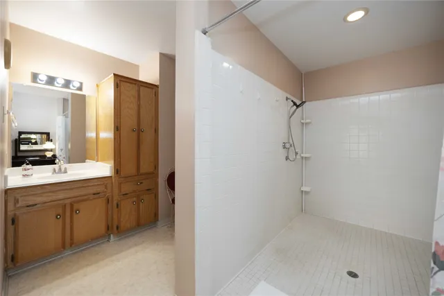 a bathroom with a double vanity sink a toilet and shower