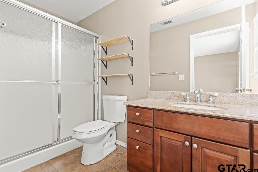 228 Cambridge Lane Longview, TX 75601 - Photo 11 of 26 a bathroom with a granite countertop sink toilet and shower