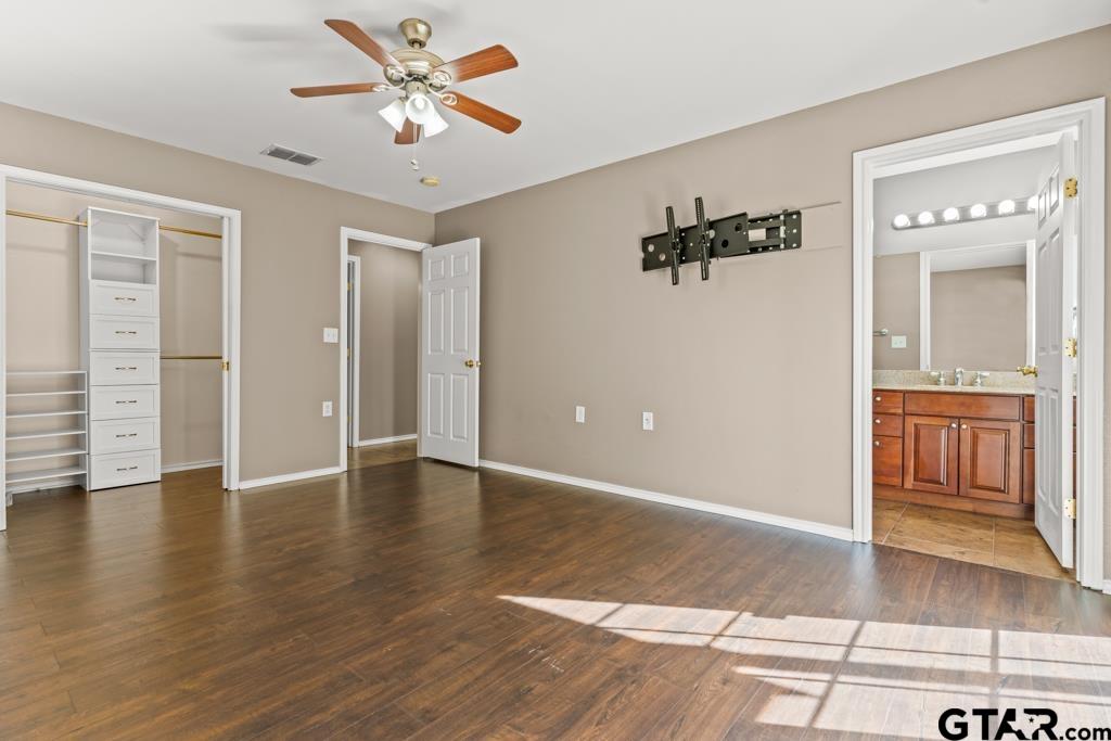 228 Cambridge Lane Longview, TX 75601 - Photo 6 of 26 an empty room with wooden floor and a ceiling fan