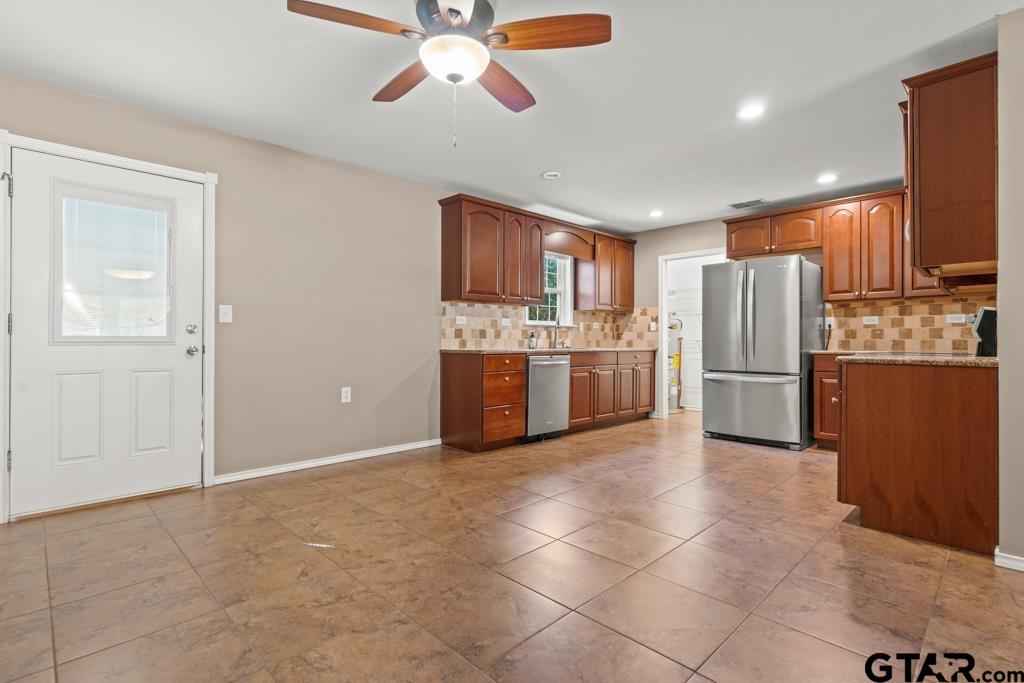 228 Cambridge Lane Longview, TX 75601 - Photo 9 of 26 a kitchen with stainless steel appliances granite countertop a refrigerator and a sink