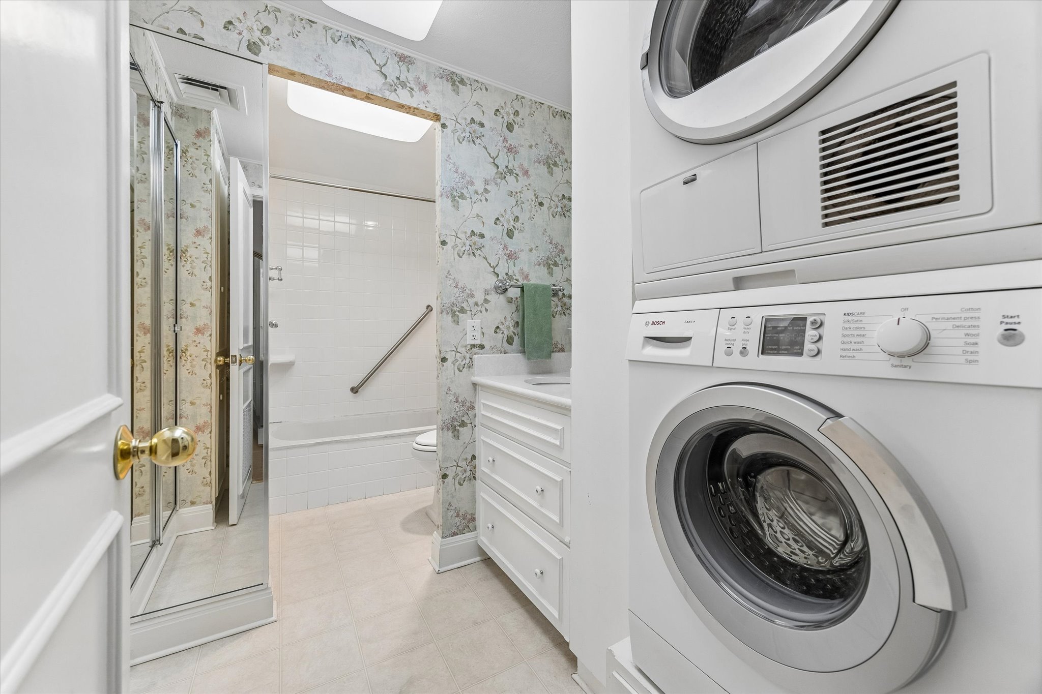 1801 Lavaca Street, Unit 6E Austin, TX 78701 - Photo 15 of 32 Washer /Dryer in unit. Laundry area featuring wallpapered walls and stacked washer and clothes dryer